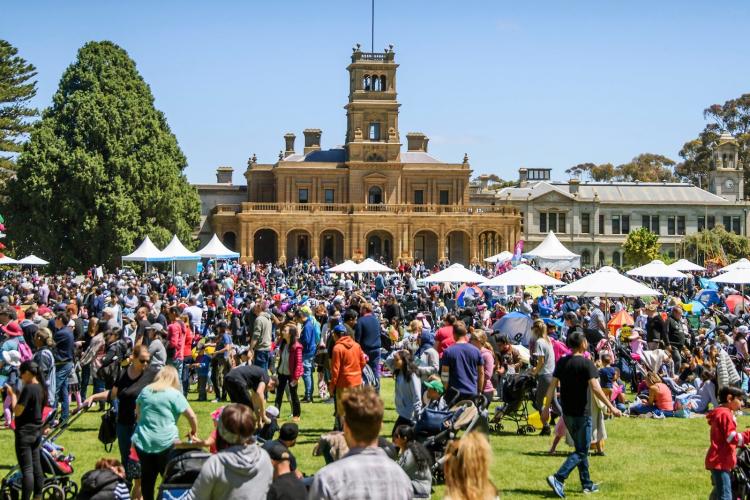 crowd gathered in front of Werribee Park Mansion on a sunny day