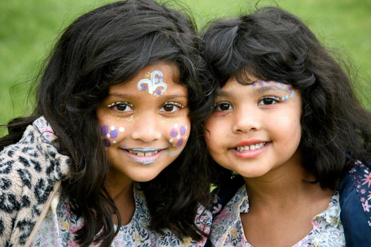 two children with their faces painted smiling